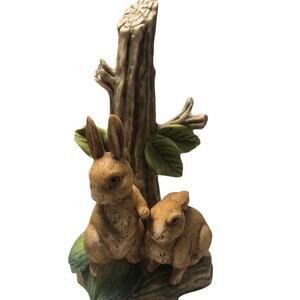 Two Wide Eyed Rabbits looking for trouble next to tree trunk